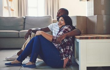 couple unpacking boxes in new home