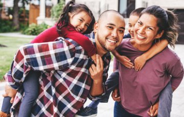 happy family in front of their new home