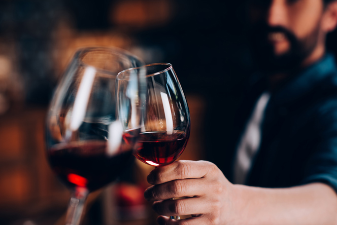A man toasting with a glass of red wine. A man toasting with a glass of red wine.